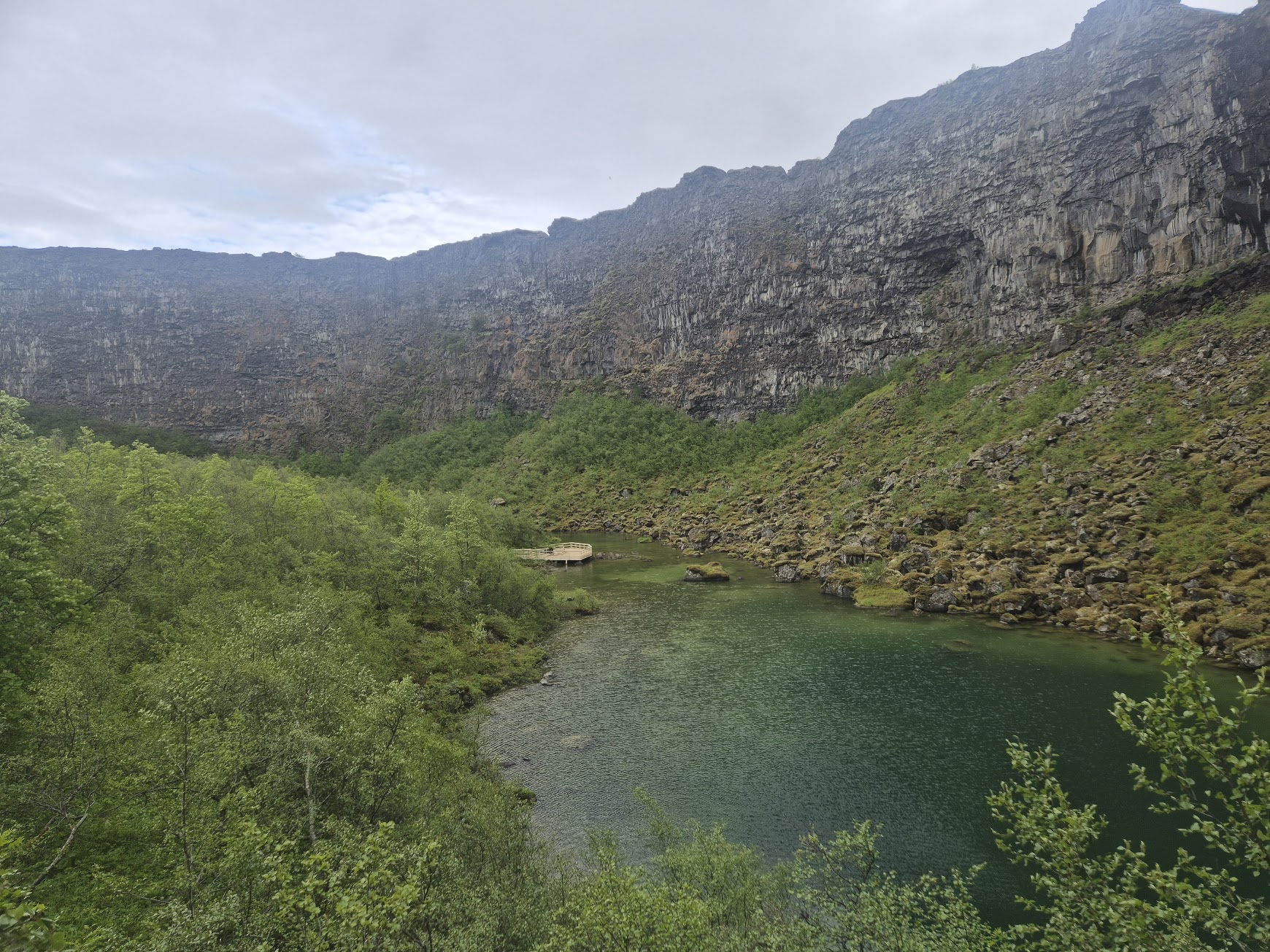 Ásbyrgi pond and viewing deck framed by the horseshoe-shaped cliffs