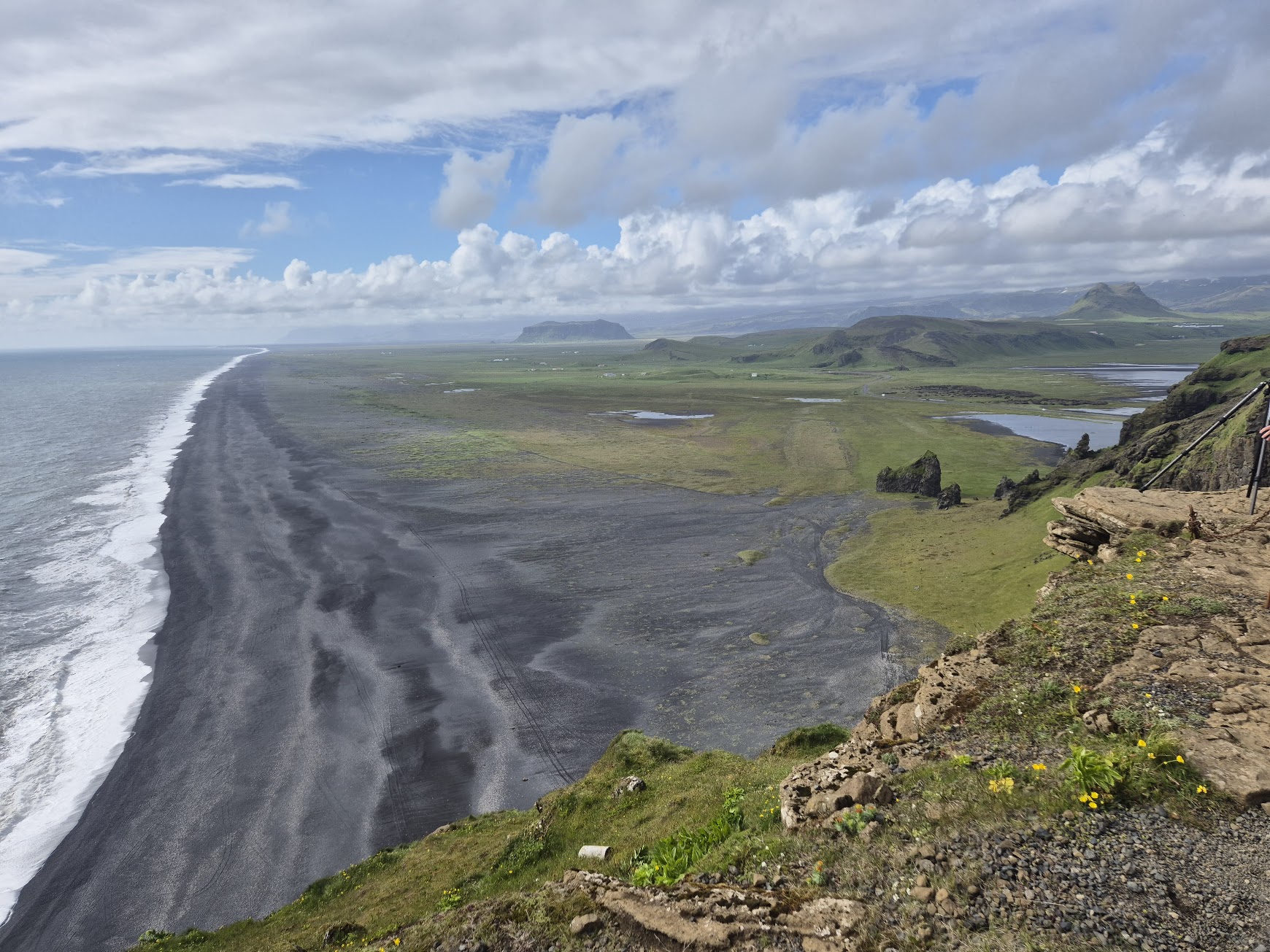 View from Dyrhólaey along the long black sand beach toward inland mountains