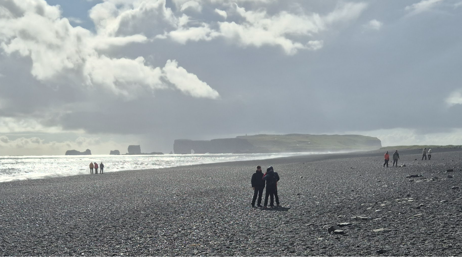 Black pebble beach below Dyrhólaey with sea stacks in the distance