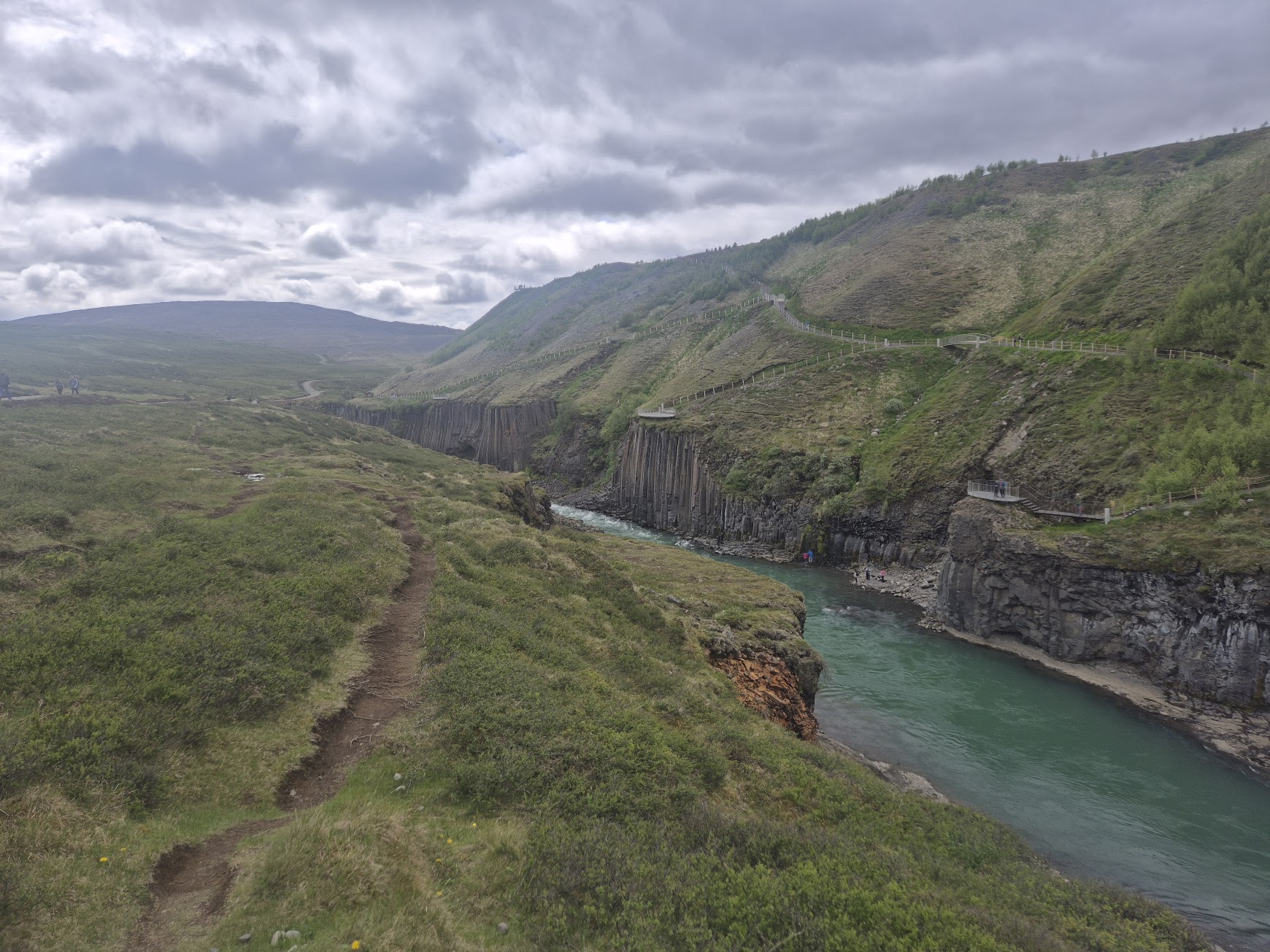 Long view down Stuðlagil canyon with the basalt walls dropping into the green-blue river