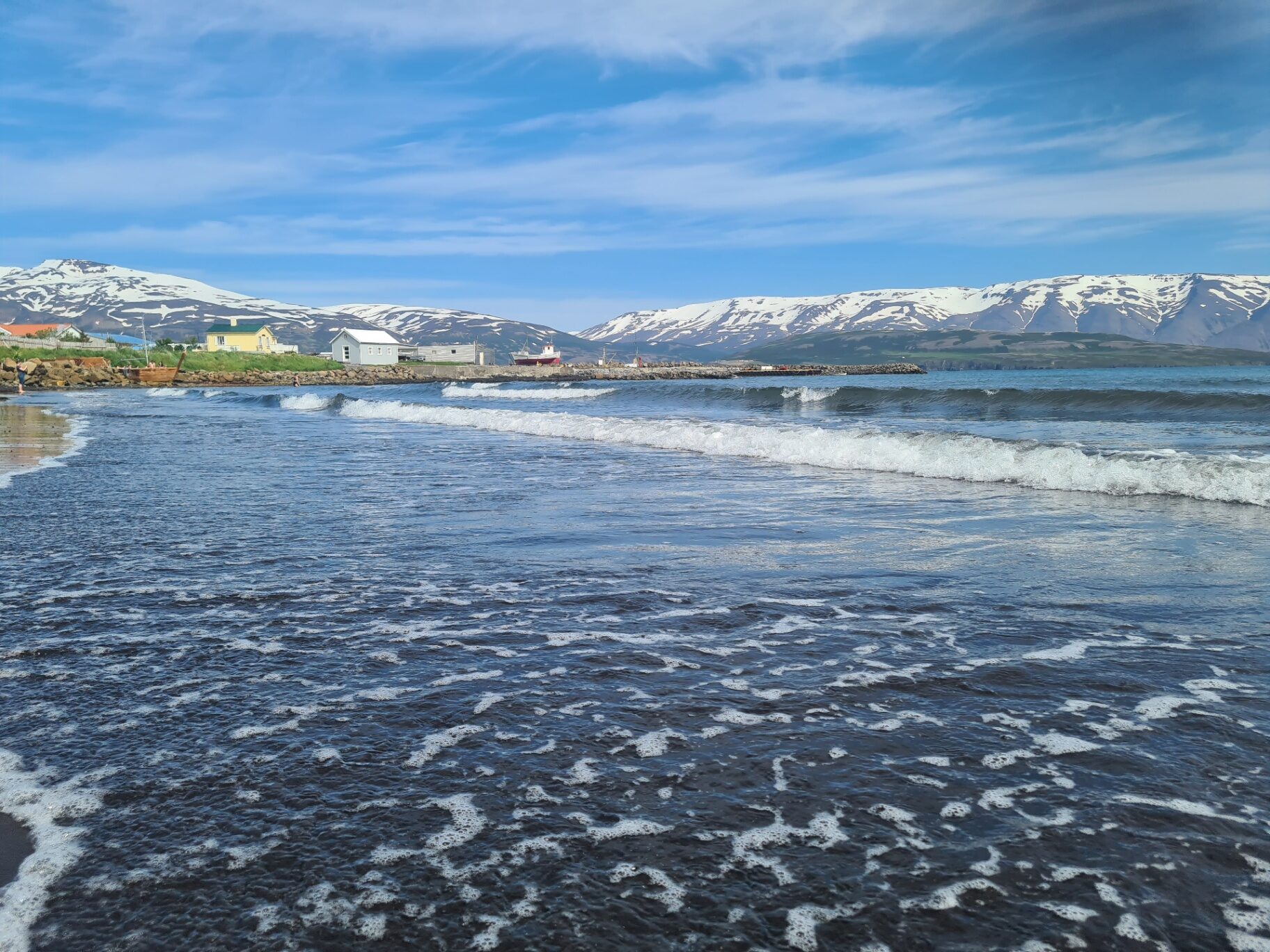 Snowy Iceland mountains above a calm coastal bay